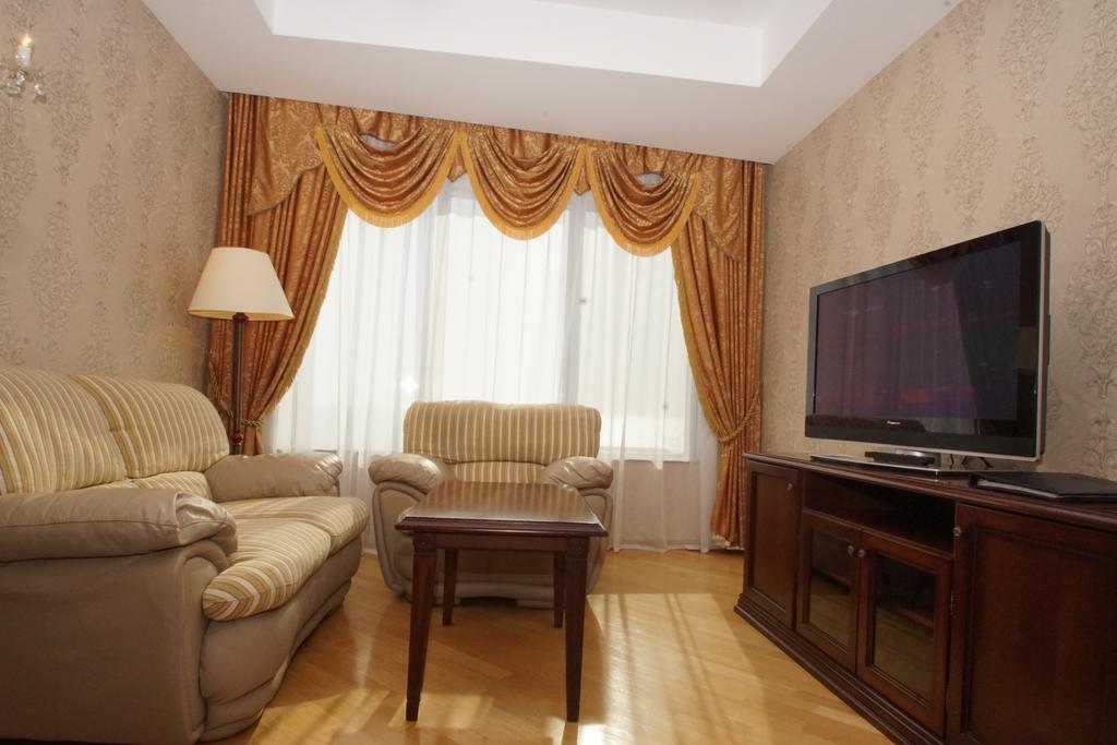 Grand Hotel Victory Aktau  Ngoại thất bức ảnh A living room with a television
